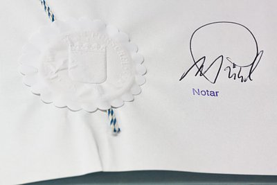 Der Notar besiegelt den Kaufvertrag notariell mit Unterschrift und Siegel.